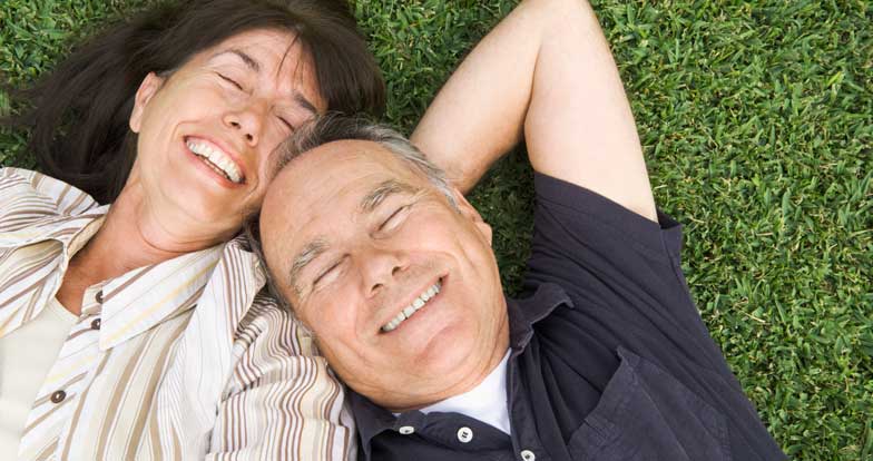 senior couple lying in grass