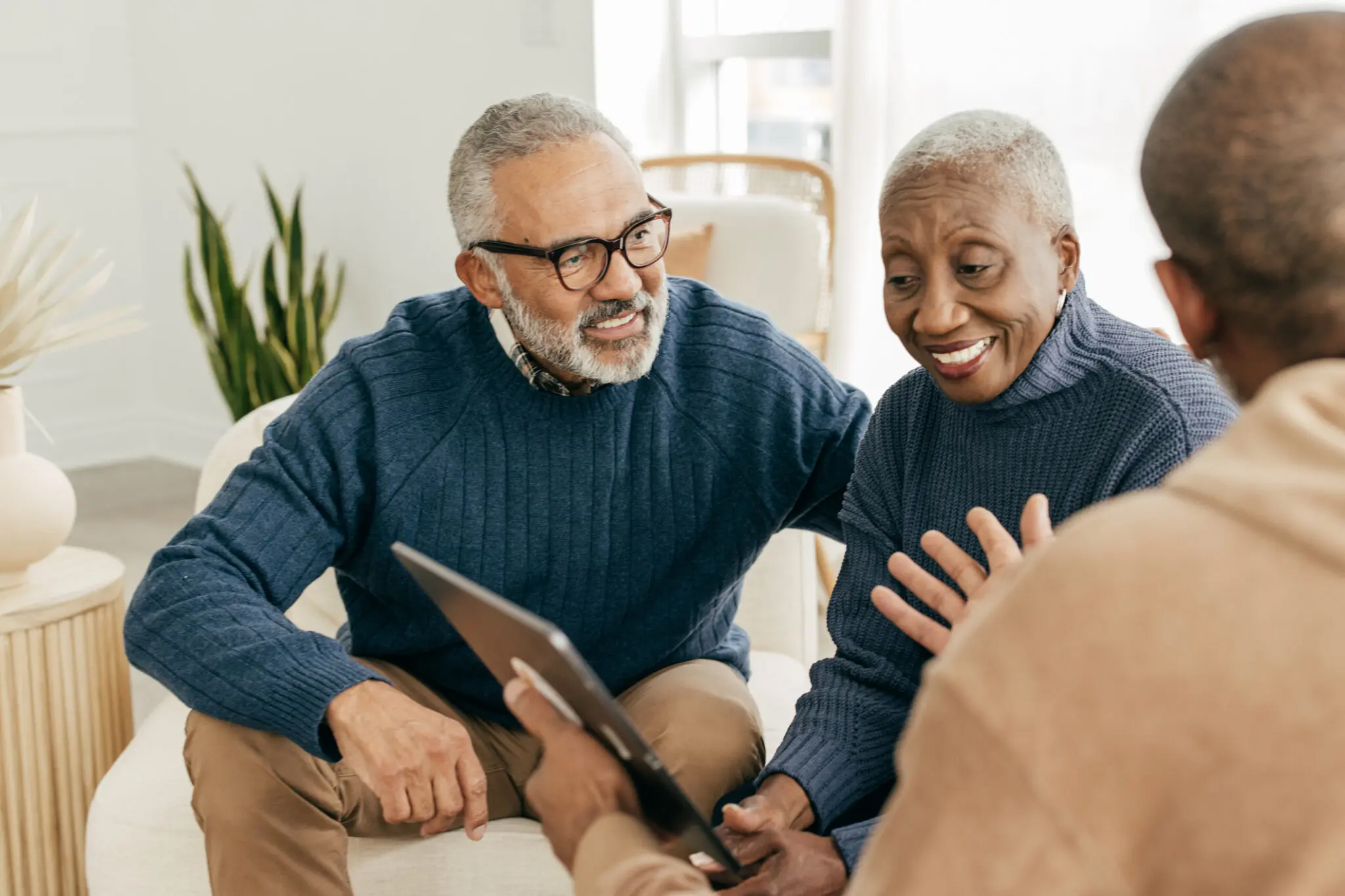 Elderly couple using a laptop while smiling and sitting close to one another