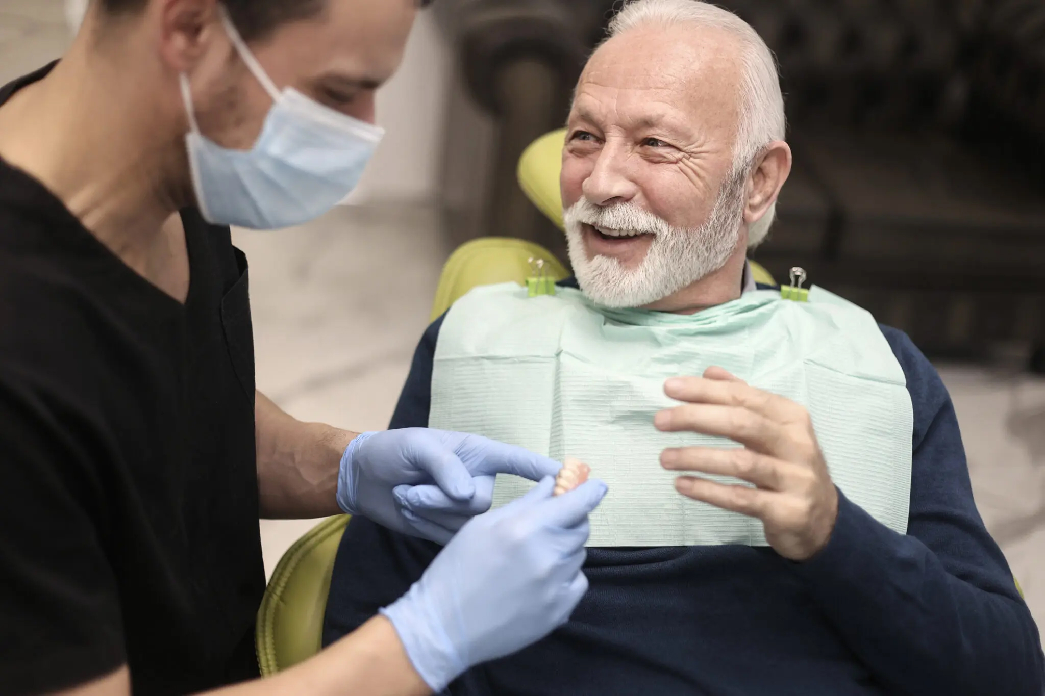 "Elderly man smiles during routine dental visit"