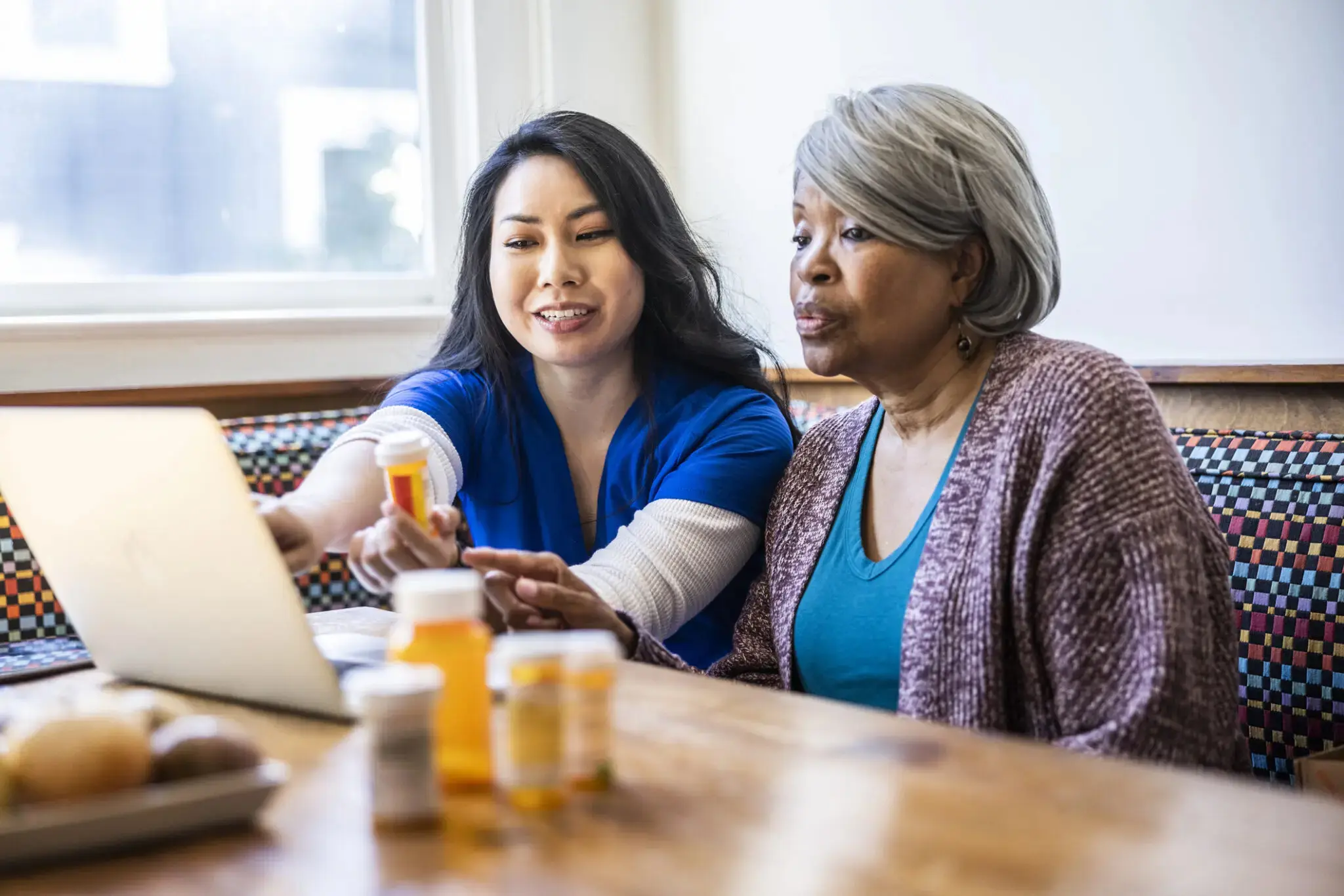 A nurse helps a senior woman manage her medication.